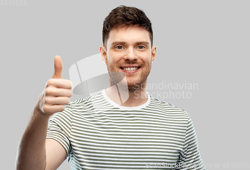 Image of smiling young man showing thumbs up