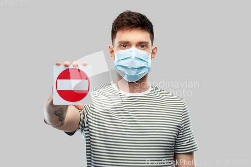 Image of young man girl in medical mask showing stop sign