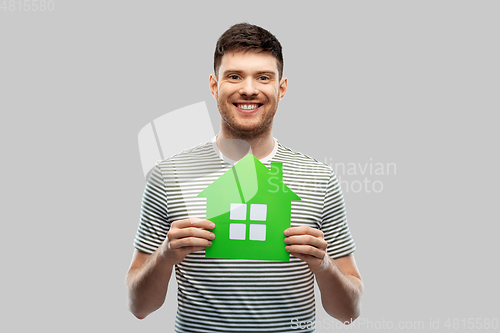 Image of smiling young man holding green house icon