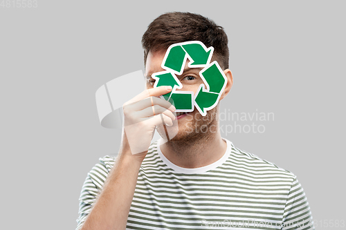 Image of smiling young man holding green recycling sign