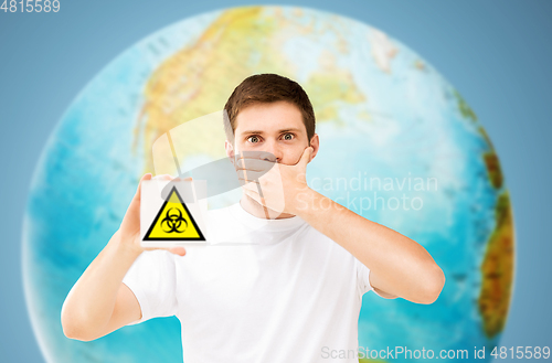 Image of scared man with biohazard sign over earth planet