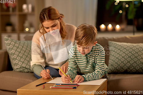 Image of mother and son with pencils drawing at home