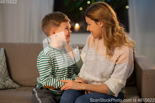 Image of happy smiling mother talking to her son at home