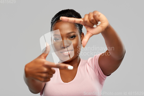 Image of happy african american woman making frame gesture