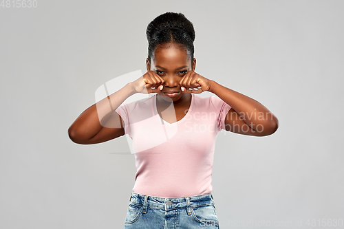 Image of sad african american woman making crying gesture