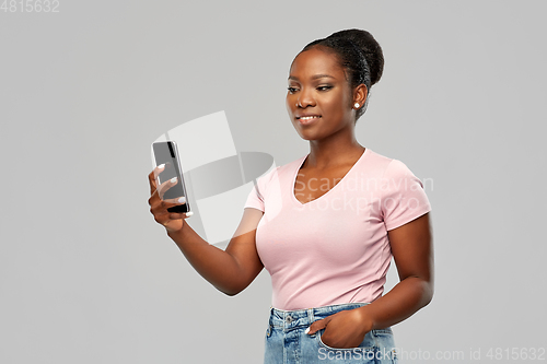 Image of happy african american woman using smartphone