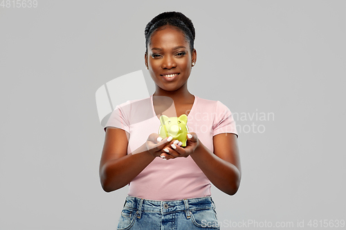 Image of happy african american woman with piggy bank