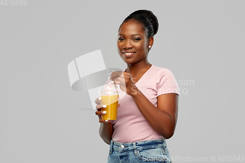 Image of happy african american woman drinking orange juice
