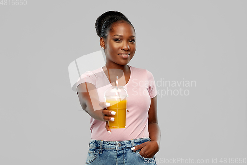 Image of happy african american woman drinking orange juice