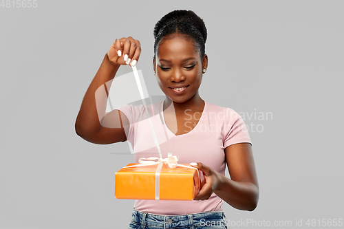 Image of happy african american woman with gift box