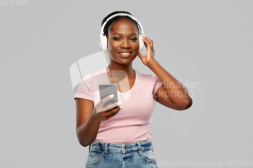 Image of african woman in headphones listening to music