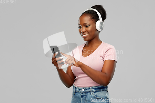 Image of african woman in headphones listening to music