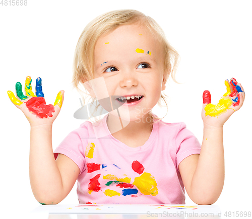 Image of Portrait of a cute little girl playing with paints