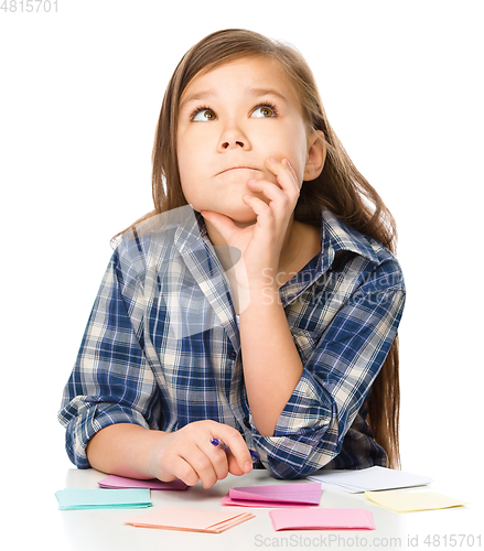 Image of Girl is writing on color stickers using pen
