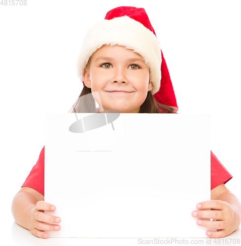 Image of Little girl in santa hat is holding blank board