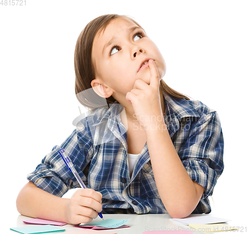 Image of Girl is writing on color stickers using pen