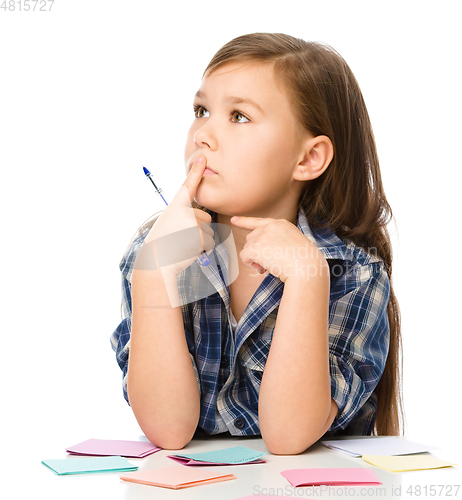 Image of Girl is writing on color stickers using pen
