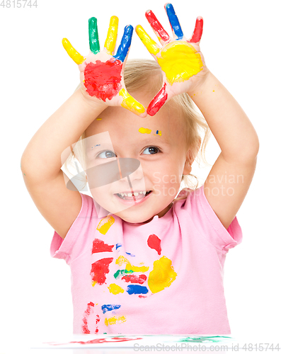 Image of Portrait of a cute little girl playing with paints