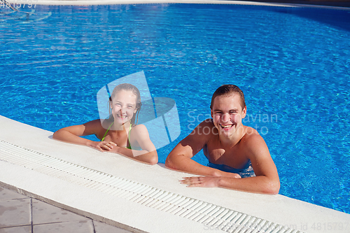 Image of boy and girl having fun in swimming pool