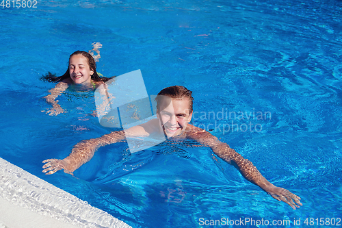 Image of boy and girl having fun in swimming pool