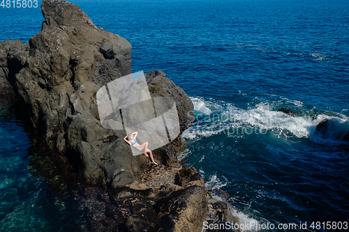 Image of beautiful girl resting in natural ocean swimming pool