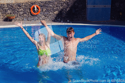 Image of boy and girl having fun in swimming pool