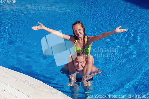 Image of boy and girl having fun in swimming pool