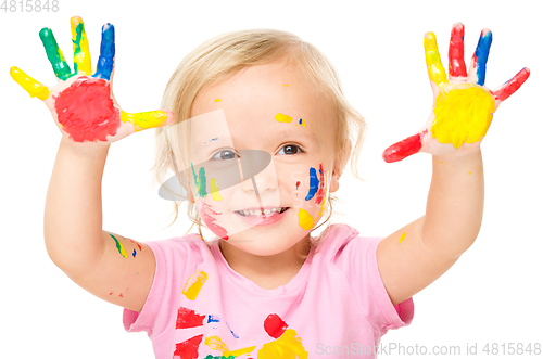 Image of Portrait of a cute little girl playing with paints