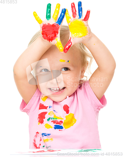 Image of Portrait of a cute little girl playing with paints