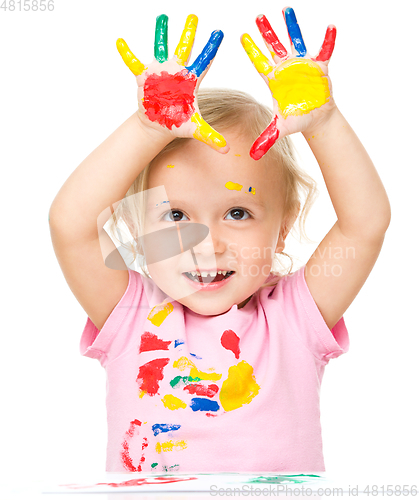 Image of Portrait of a cute little girl playing with paints