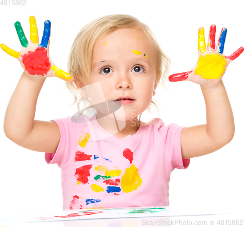 Image of Portrait of a cute little girl playing with paints