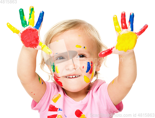 Image of Portrait of a cute little girl playing with paints