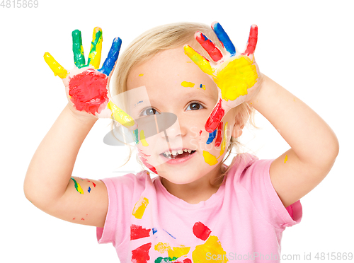 Image of Portrait of a cute little girl playing with paints