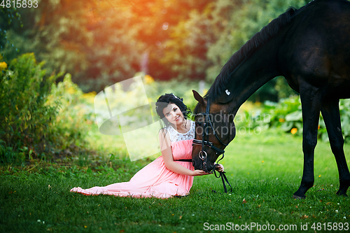 Image of beautiful girl in dress with horse