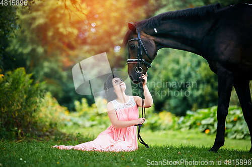 Image of beautiful girl in dress with horse