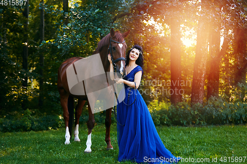 Image of beautiful girl in dress with horse