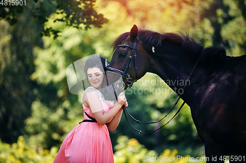 Image of beautiful girl in dress with horse