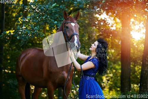 Image of beautiful girl in dress with horse