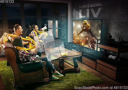 Image of Group of friends watching TV, american football championship