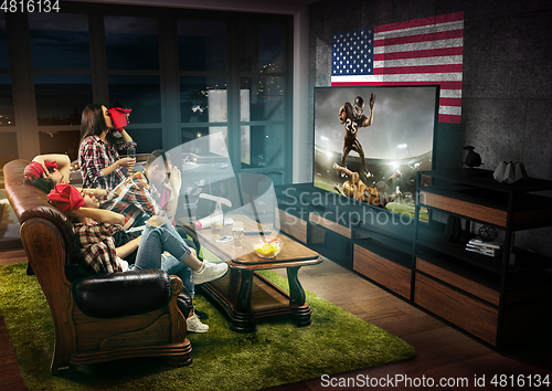 Image of Group of friends watching TV, american football championship