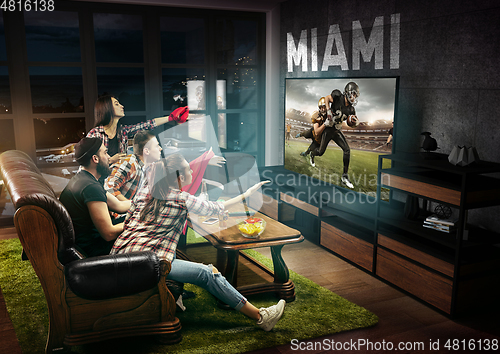 Image of Group of friends watching TV, american football championship