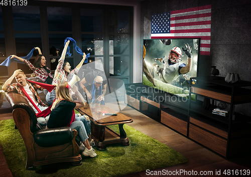 Image of Group of friends watching TV, american football championship