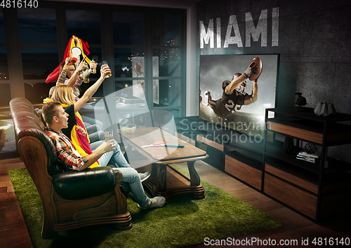 Image of Group of friends watching TV, american football championship