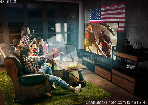 Image of Group of friends watching TV, american football championship