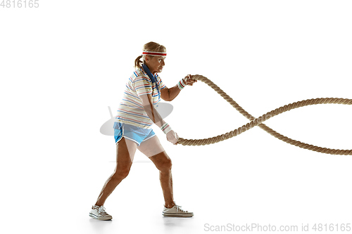 Image of Senior woman training with ropes in sportwear on white background