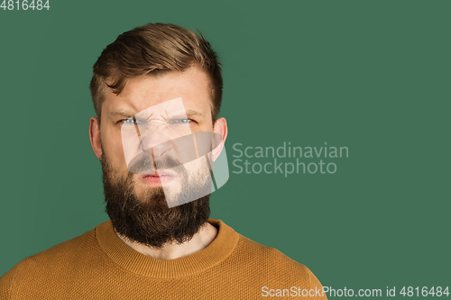 Image of Caucasian man\'s portrait isolated over green studio background with copyspace