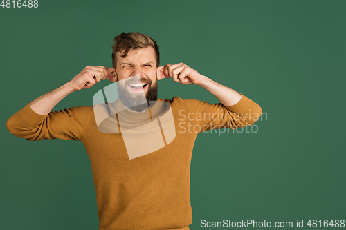 Image of Caucasian man\'s portrait isolated over green studio background with copyspace