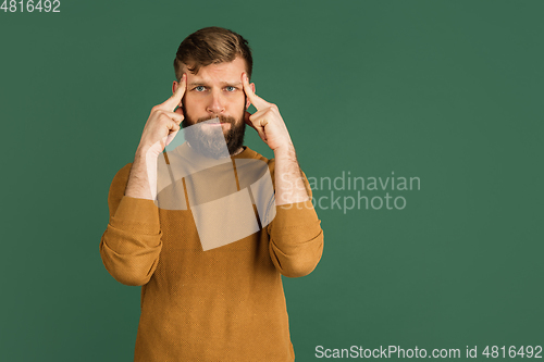Image of Caucasian man\'s portrait isolated over green studio background with copyspace