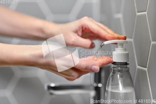 Image of close up of woman washing hands with liquid soap