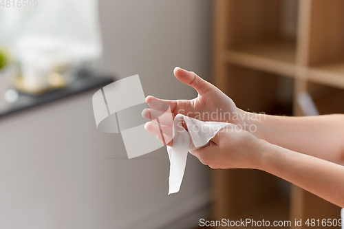 Image of woman cleaning hands with antiseptic wet wipe